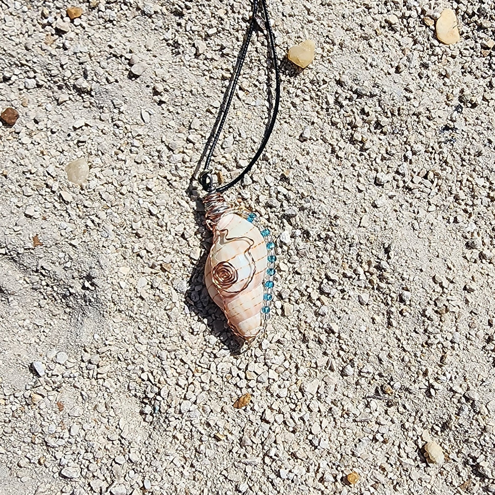 Handmade tulip shell pendant necklace with copper wire wrap, blue ceramic bead, and glass beads on cord