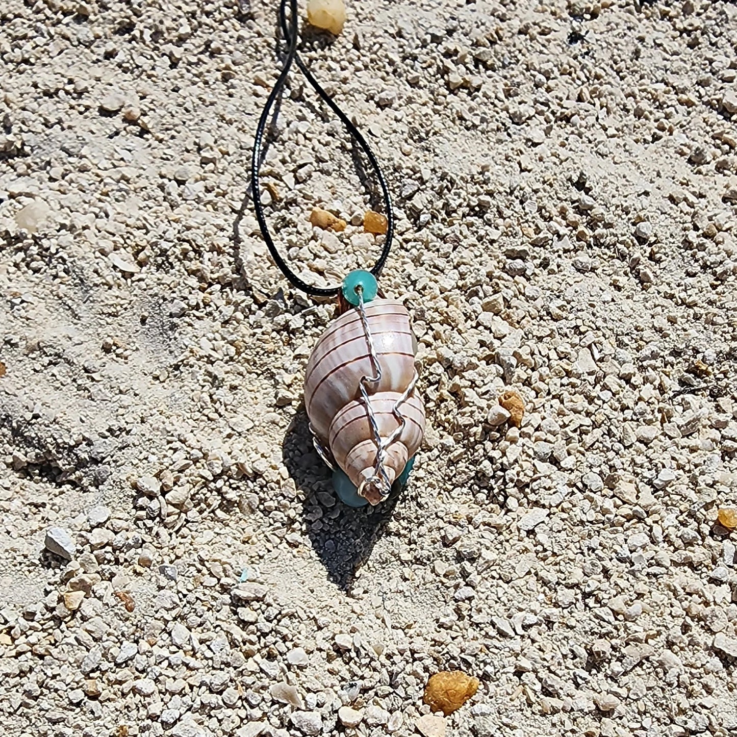 Handmade tulip shell pendant necklace with mixed metal wire wrap, turquoise beads, and wood accents on cord