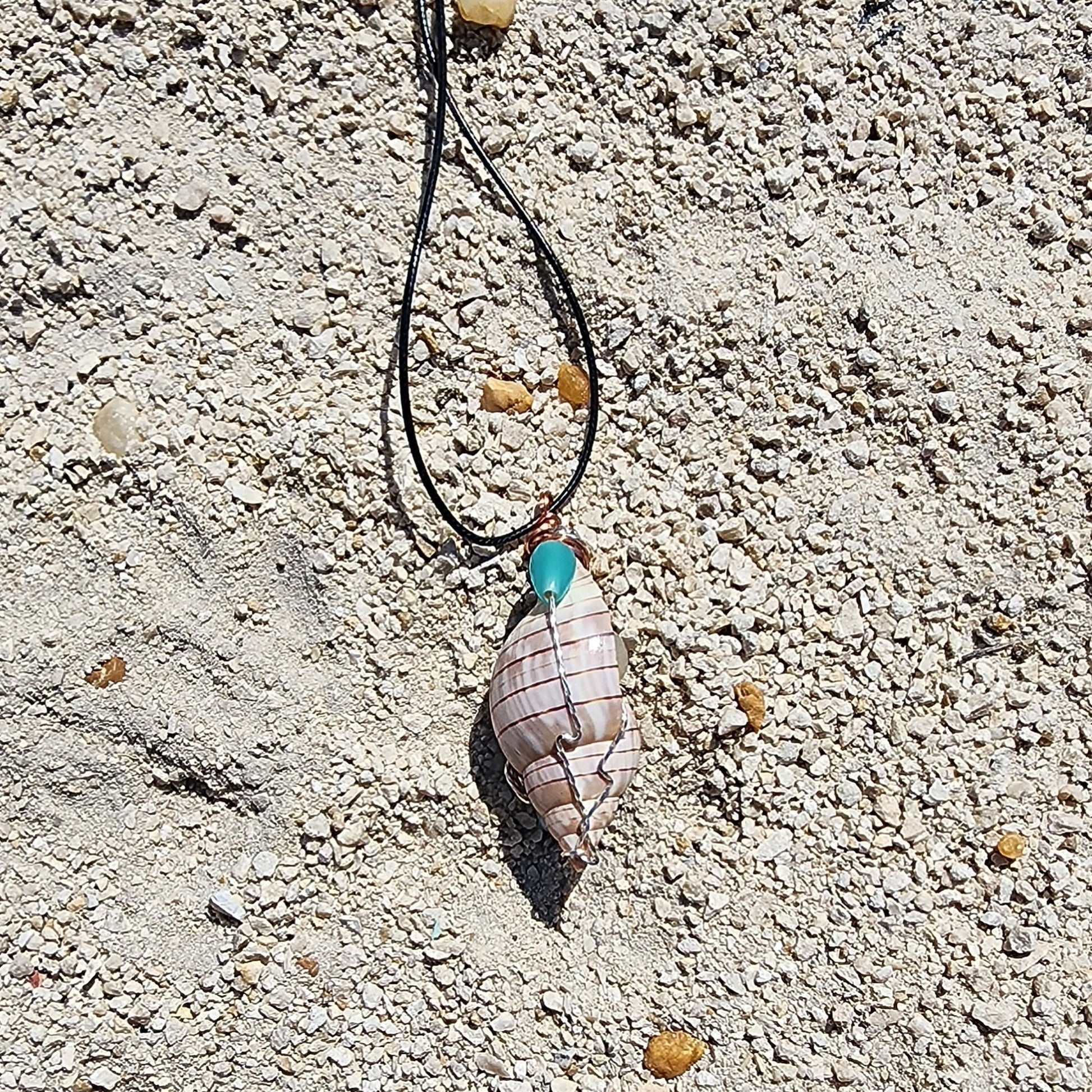 Handmade tulip shell pendant necklace with mixed metal wire wrap, turquoise beads, and wood accents on cord