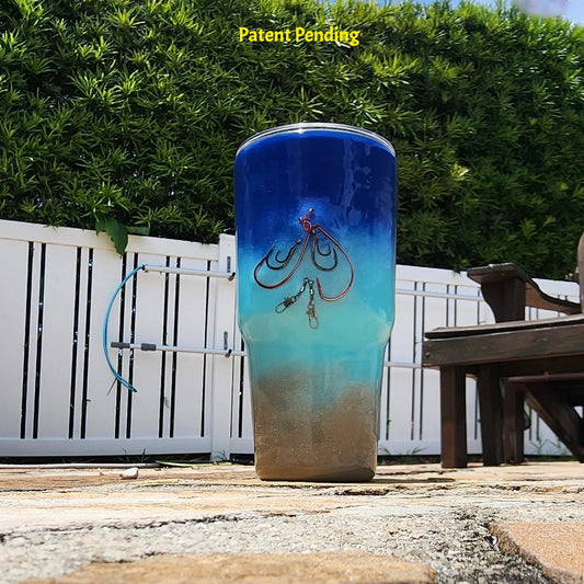Shore to Sea Blue 30oz fishing tumbler front view with real saltwater fishing hooks and barrel swivel, deep cobalt blue to Caribbean teal to sandy shore design. Hook & Tumble™ by SoFlo Boho Boutique, Patent Pending, handcrafted in South Florida.