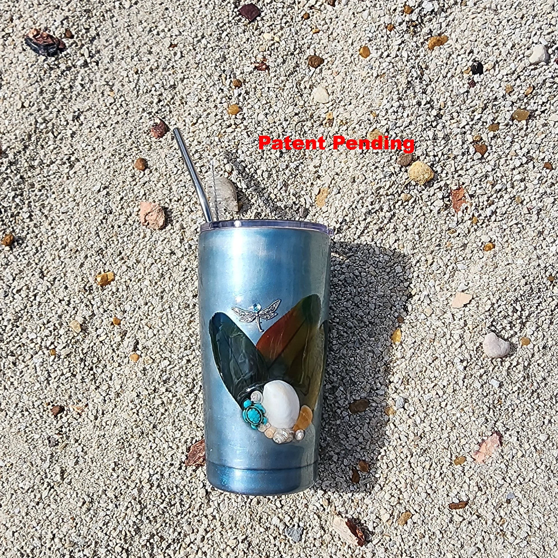 Teal insulated tumbler on beach sand with ocean-inspired shimmer finish