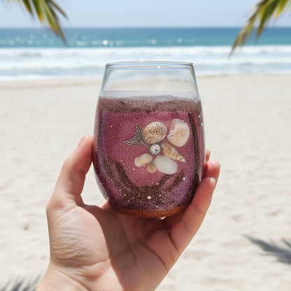 Burungdy, brown and pink glitter wine glass with Seashell held in hand with beach background