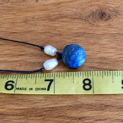 Blue gemstone pendant and pearl bead necklace size reference on tape measure