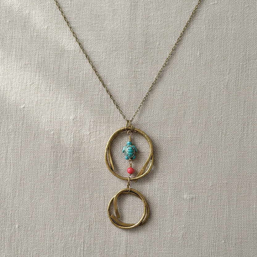 Close-up of hammered brass circles on handmade turtle pendant necklace
