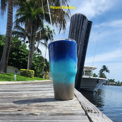Left side view of Shore to Sea Blue 30oz fishing tumbler on South Florida marina dock showing coastal blue to sand color story. Hook & Tumble™ by SoFlo Boho Boutique, Patent Pending.