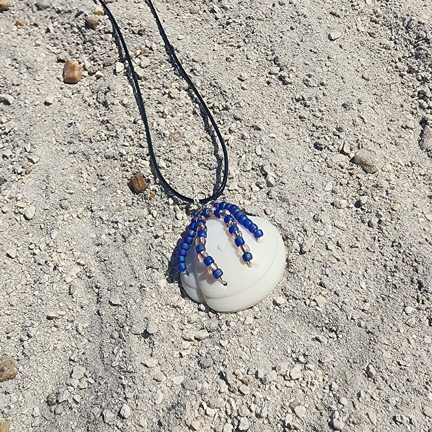 White Lucina shell pendant necklace with silver wire wrap and purple bead strands