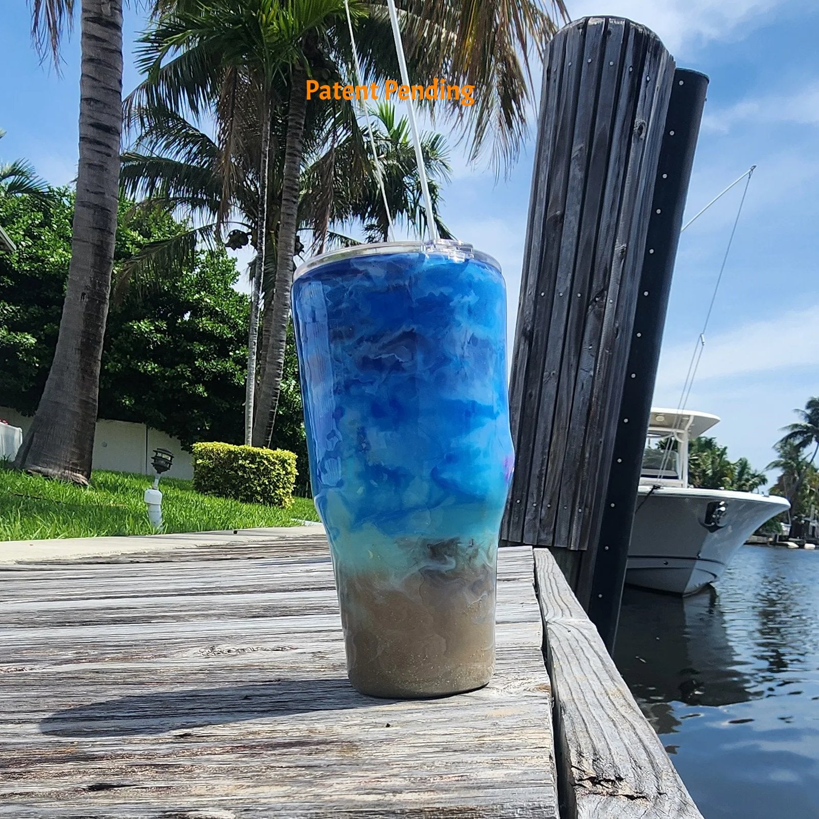 Left side view of Crystal Shore Deep 30oz fishing tumbler on South Florida marina dock showing glow-in-the-dark speckled shrimp hook and saltwater fish hooks with waterway in background. Hook & Tumble™ by SoFlo Boho Boutique, Patent Pending.
