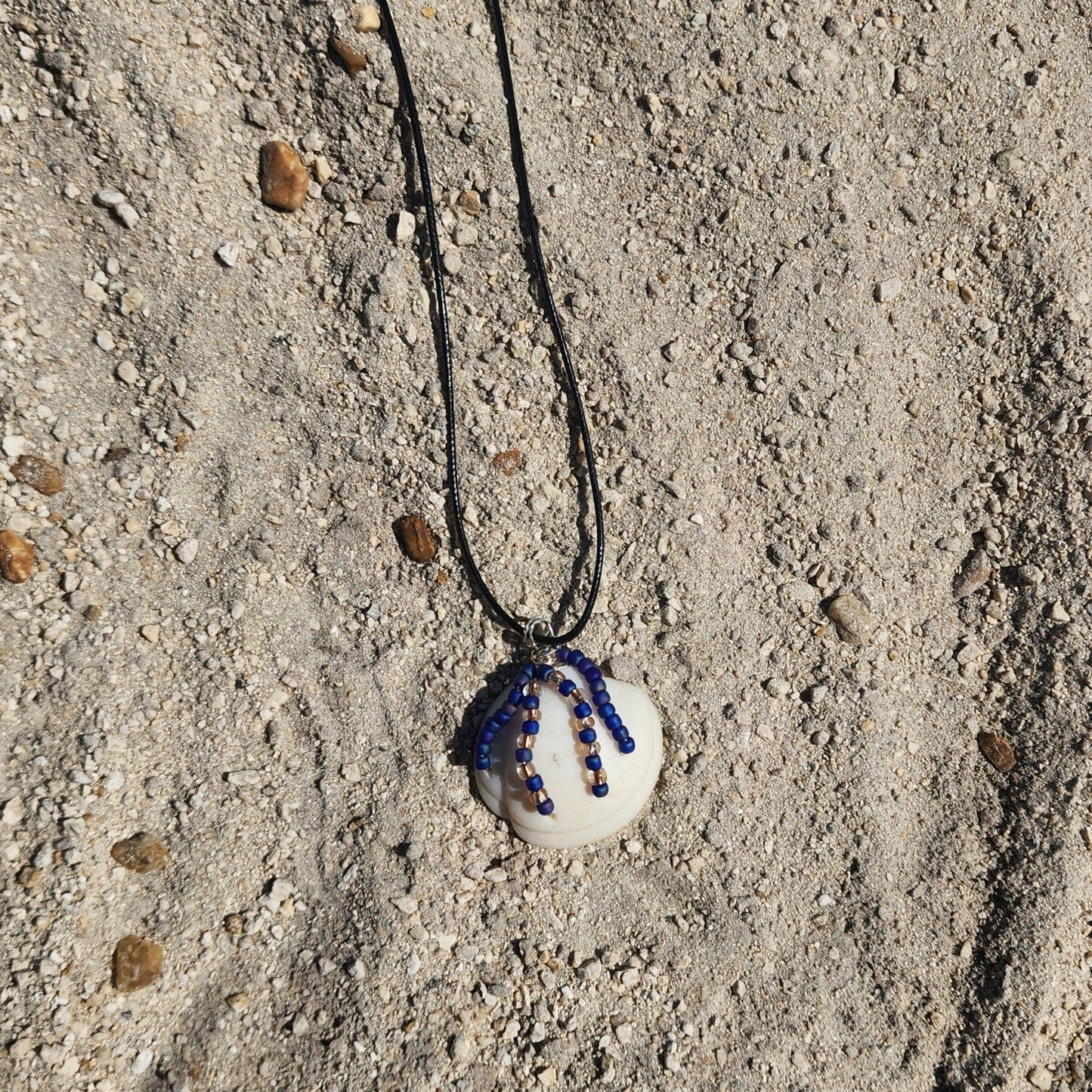 Handmade Lucina shell pendant necklace with silver wire wrap and purple bead strands