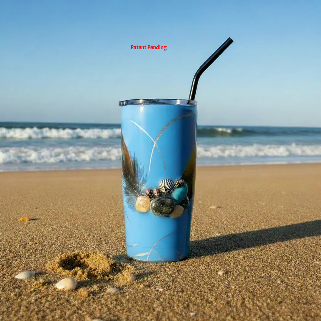 blue tumbler with seashell and feather on the beach