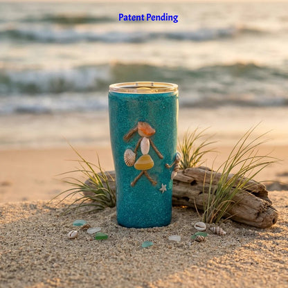 Saltwater Sips 20oz tumbler with a seashell figure on driftwood by the ocean