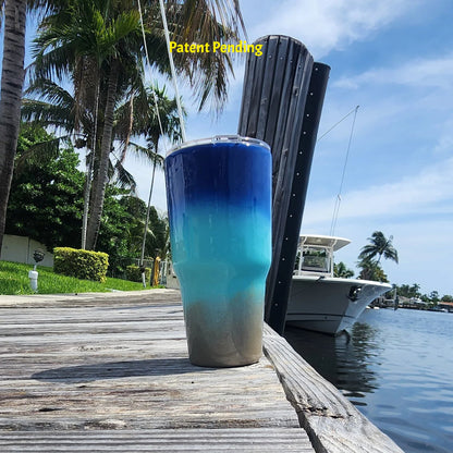 Back view of Shore to Sea Blue 30oz fishing tumbler on South Florida marina dock showing full cobalt blue to Caribbean teal to sandy shore design. Hook & Tumble™ by SoFlo Boho Boutique, handcrafted in South Florida, Patent Pending
