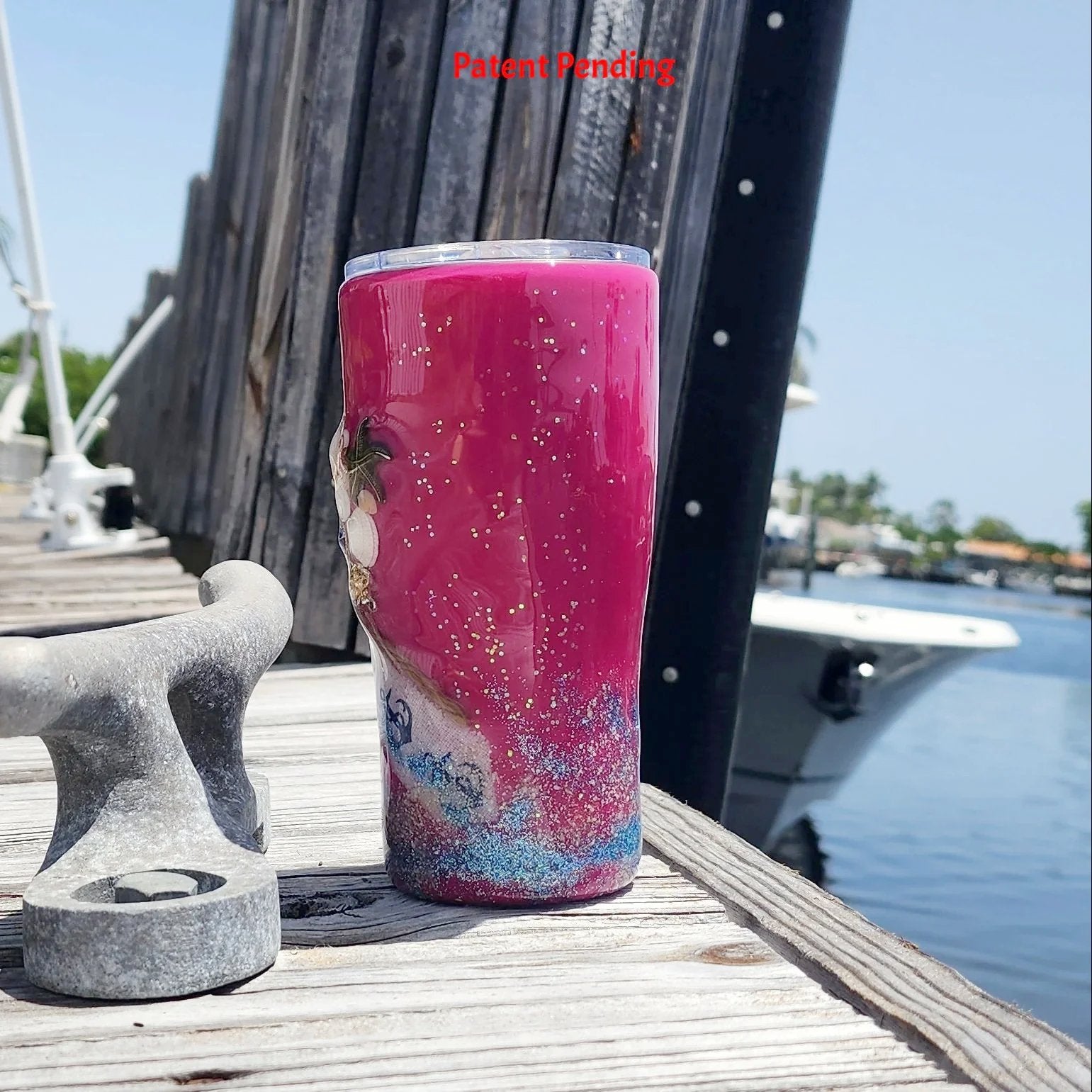 Back view of the 20oz Saltwater Sips beach tumbler, displaying the clean, vibrant high-gloss magenta finish meeting the blue glittered tideline and textured real sand base.